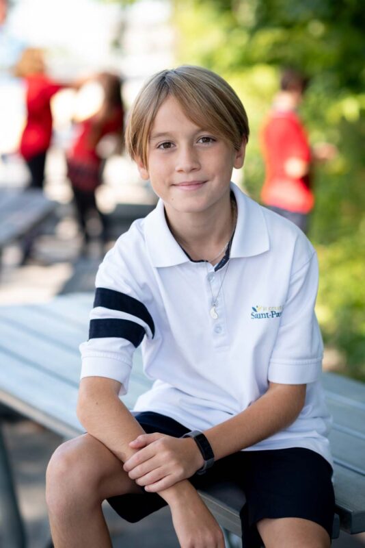 Élève de 1re secondaire avec un polo blanc au Collège Saint-Paul